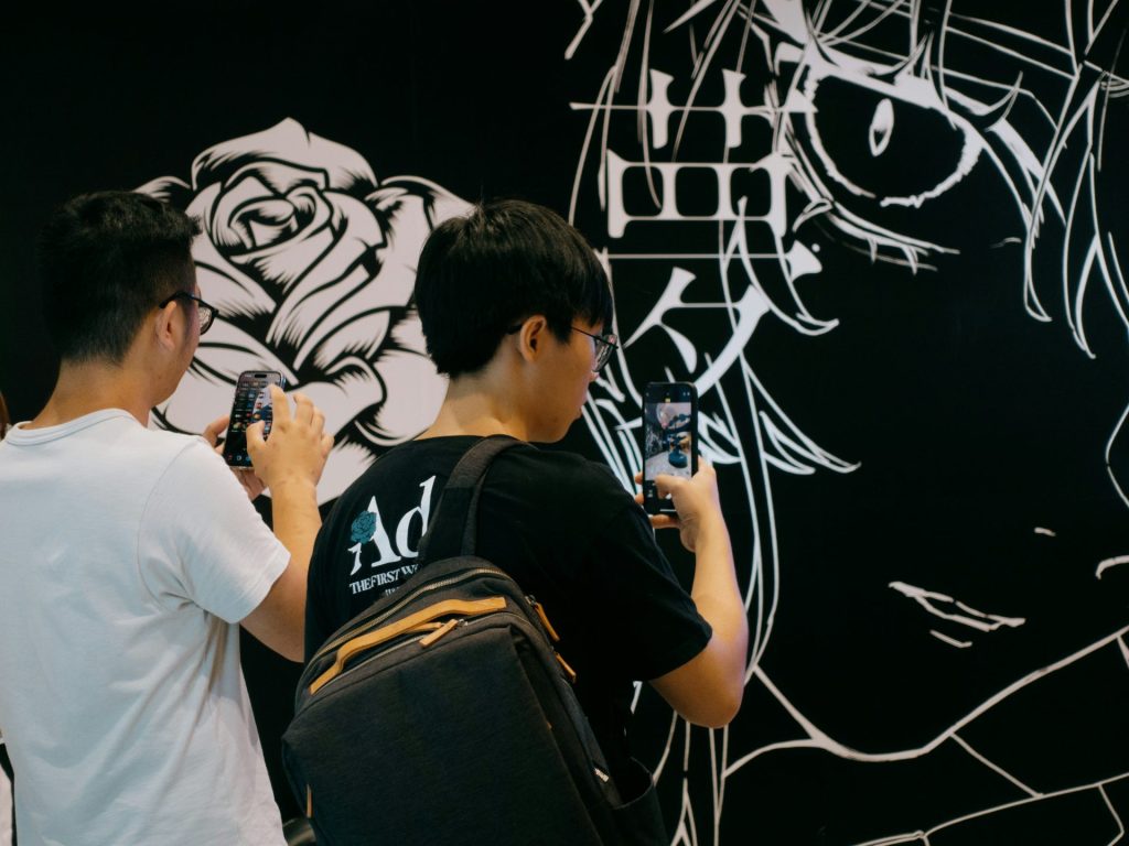 Two men taking pictures of graffiti on a wall