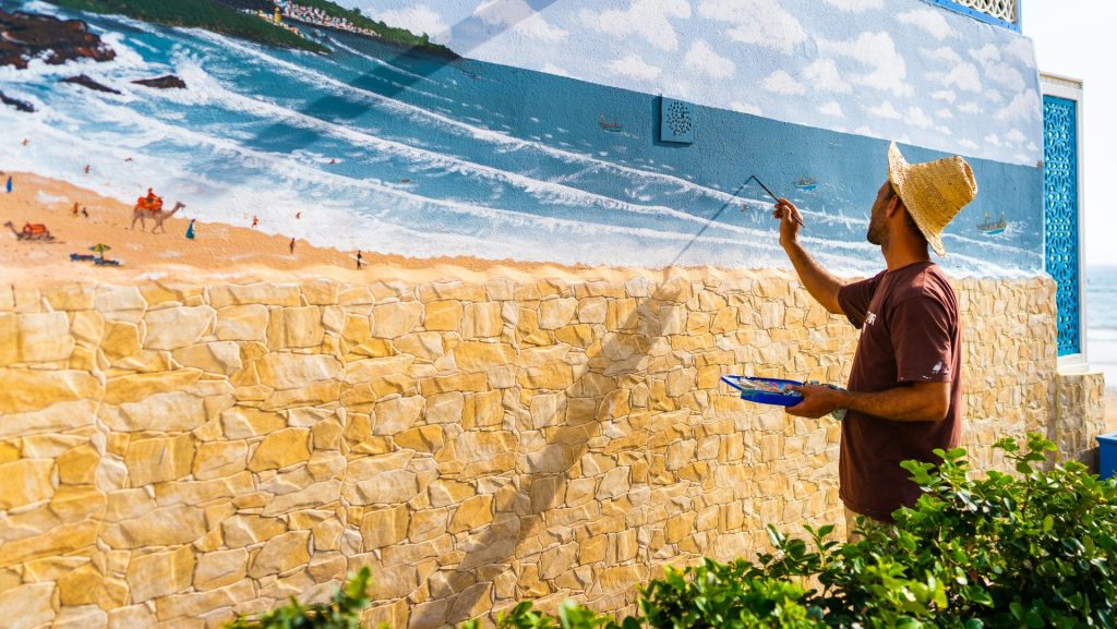person wearing black shirt painting on wall during daytime